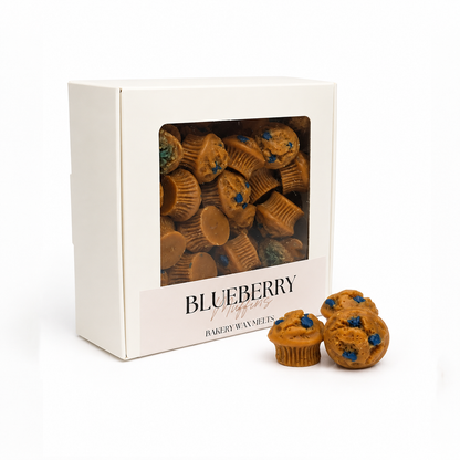 Box of blueberry muffin-shaped bakery wax melts with two melts in front on a white background