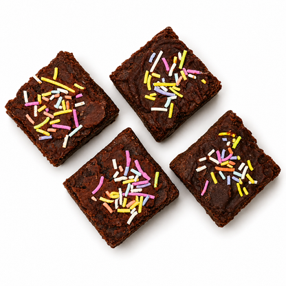 Four chocolate brownies with colorful sprinkles on a white background