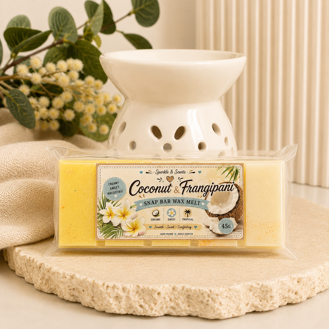 Coconut and Frangipani wax melt bar with packaging on a decorative surface.